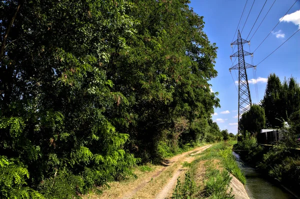 Sentiero Sterrato Delimitato Corso Acqua Con Traliccio Elettrico Nella Campagna — Foto Stock