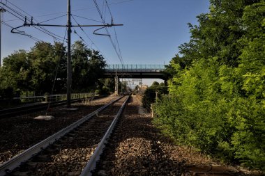 Gün batımında kırsal alanda açık gökyüzü olan demiryolu köprüsü.