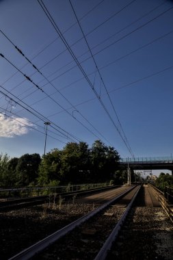 Gün batımında kırsal alanda açık gökyüzü olan demiryolu köprüsü.