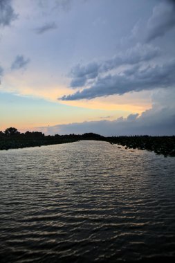 Alacakaranlıkta bulutlu bir günde nehirdeki kanal