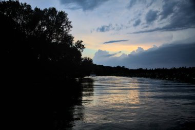 Alacakaranlıkta bulutlu bir günde nehirdeki kanal