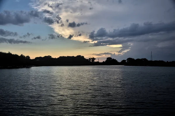 Gün Batımında Nehir Kenarındaki Bir Parkın Silüeti — Stok fotoğraf