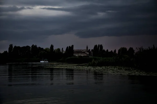 日没時にイタリアの田舎の距離に聖域と曇りの日に沼の川 — ストック写真