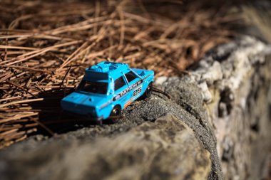 Cenova, İtalya - 17. SEPTEMBER 2025 1970 'lerdeki bir Datsun 510 Rallisi' nin kibrit kutusu kopyası yanında çam iğneleriyle bir dağ sırtında koşuyormuş gibi yapıyor.