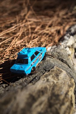 Cenova, İtalya - 17. SEPTEMBER 2025 1970 'lerdeki bir Datsun 510 Rallisi' nin kibrit kutusu kopyası yanında çam iğneleriyle bir dağ sırtında koşuyormuş gibi yapıyor.