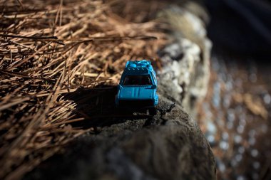 Cenova, İtalya - 17. SEPTEMBER 2025 1970 'lerdeki bir Datsun 510 Rallisi' nin kibrit kutusu kopyası yanında çam iğneleriyle bir dağ sırtında koşuyormuş gibi yapıyor.