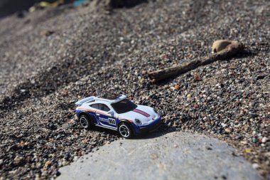 Cenova, İtalya - 17. SEPTEMBER 2025 - Rothmans 'taki bir taşın üzerinde çölde koşuyormuş gibi yapan Porsche 911 Rallye' nin kopyası