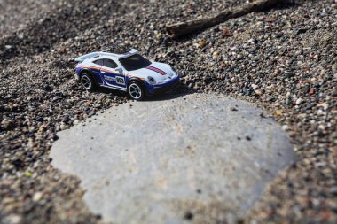 Cenova, İtalya - 17. SEPTEMBER 2025 - Rothmans 'taki bir taşın üzerinde çölde koşuyormuş gibi yapan Porsche 911 Rallye' nin kopyası