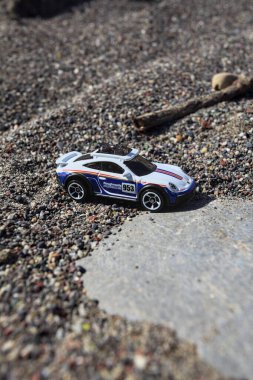 Cenova, İtalya - 17. SEPTEMBER 2025 - Rothmans 'taki bir taşın üzerinde çölde koşuyormuş gibi yapan Porsche 911 Rallye' nin kopyası