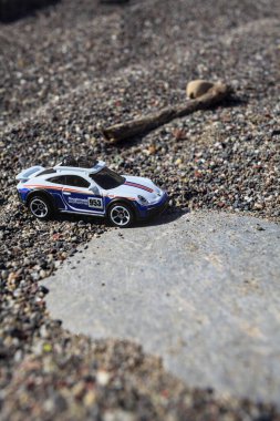 Cenova, İtalya - 17. SEPTEMBER 2025 - Rothmans 'taki bir taşın üzerinde çölde koşuyormuş gibi yapan Porsche 911 Rallye' nin kopyası