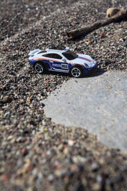 Cenova, İtalya - 17. SEPTEMBER 2025 - Rothmans 'taki bir taşın üzerinde çölde koşuyormuş gibi yapan Porsche 911 Rallye' nin kopyası