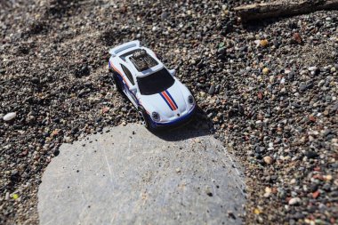 Cenova, İtalya - 17. SEPTEMBER 2025 - Rothmans 'taki bir taşın üzerinde çölde koşuyormuş gibi yapan Porsche 911 Rallye' nin kopyası