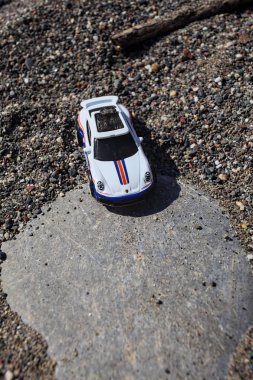 Cenova, İtalya - 17. SEPTEMBER 2025 - Rothmans 'taki bir taşın üzerinde çölde koşuyormuş gibi yapan Porsche 911 Rallye' nin kopyası