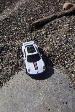 Cenova, İtalya - 17. SEPTEMBER 2025 - Rothmans 'taki bir taşın üzerinde çölde koşuyormuş gibi yapan Porsche 911 Rallye' nin kopyası