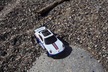 Cenova, İtalya - 17. SEPTEMBER 2025 - Rothmans 'taki bir taşın üzerinde çölde koşuyormuş gibi yapan Porsche 911 Rallye' nin kopyası
