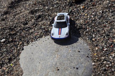 Cenova, İtalya - 17. SEPTEMBER 2025 - Rothmans 'taki bir taşın üzerinde çölde koşuyormuş gibi yapan Porsche 911 Rallye' nin kopyası