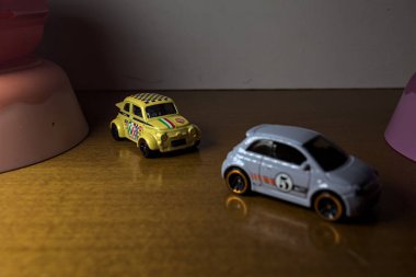 Mantova, İtalya - 3RD SEPTEMBER 2025 - Fiat 500e 'nin Hot Wheels kopyaları ve iki döner kavşak arasında bir yarış varmış gibi görünen plastik kaseler arasında bir Fiat 500d
