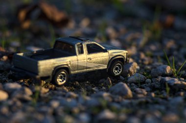 Stradella, İtalya - 10 Ekim 2025 - 2017 Nissan Hardbody 'in çakıl taşı ve çimenlerin gün batımında kibrit kutusu kopyası