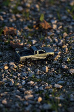 Stradella, İtalya - 10 Ekim 2025 - 2017 Nissan Hardbody 'in çakıl taşı ve çimenlerin gün batımında kibrit kutusu kopyası