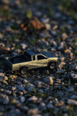 Stradella, İtalya - 10 Ekim 2025 - 2017 Nissan Hardbody 'in çakıl taşı ve çimenlerin gün batımında kibrit kutusu kopyası