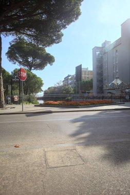 Deniz kıyısındaki bir italyan kasabasında bir korulukla suya atılan binaların arasından geçen bir nehir.