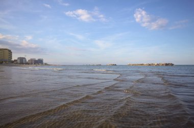 Gün batımında alçak gelgit sırasında kumsalın yanındaki binalar