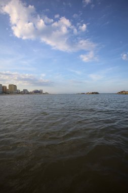 Gün batımında alçak gelgit sırasında kumsalın yanındaki binalar