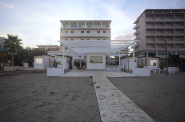 Gün batımında boş ve kapalı bir sahil tatil köyü.