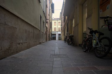 Bulutlu bir gökyüzü ile gölgede dar bir sokak