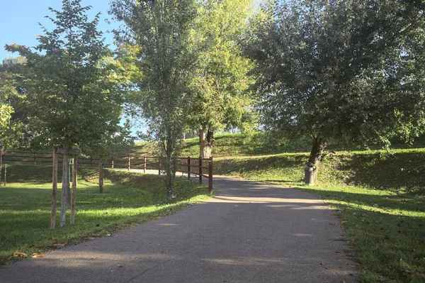 Güneşli bir günde, setin yanındaki ağaçlarla çevrili patika.