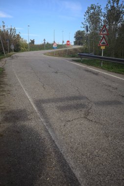 İtalya kırsalında güneşli bir günde ağaçlarla çevrili bir yol.