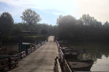 Güneşli bir günde, İtalya kırsalında ahşap platformlu ve raylı Pontoon Köprüsü