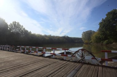 Güneşli bir günde, İtalya kırsalında ahşap platformlu ve raylı Pontoon Köprüsü