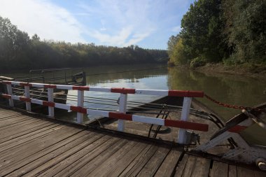 Güneşli bir günde, İtalya kırsalında ahşap platformlu ve raylı Pontoon Köprüsü