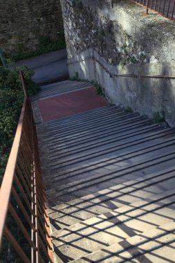 Beton merdiven kenarlarında çimenler, gölgede yolun kenarında.