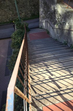 Beton merdiven kenarlarında çimenler, gölgede yolun kenarında.