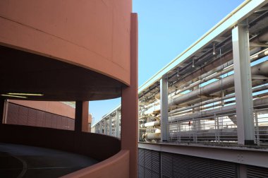 Metalik merdiven boşluğundan görülen diğer binanın yanındaki otoparkın spiral şeklindeki rampası.