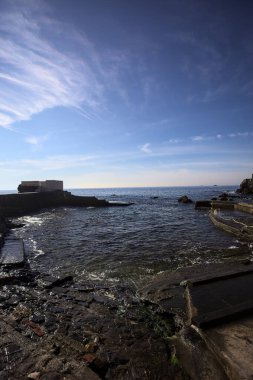 Panoramik teras, su seviyesinin yanında deniz kenarındaki birkaç kayanın üzerinde dalgaların altında ezildiği bir yapı.