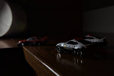 Cenova, İtalya - 20th NOVEMBER 2025 - Nissan Skyline Turbo Super Silueti 'nin kırmızı ve siyah yarış kıyafetleri içindeki Takara Tomi kopyaları Nissan Skyline GT-R R34 ve Japon polis üniformalarındaki Nissan Fairlady 350Z al