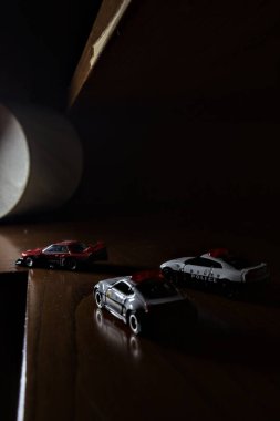 Cenova, İtalya - 20th NOVEMBER 2025 - Nissan Skyline Turbo Super Silueti 'nin kırmızı ve siyah yarış kıyafetleri içindeki Takara Tomi kopyaları Nissan Skyline GT-R R34 ve Japon polis üniformalarındaki Nissan Fairlady 350Z al