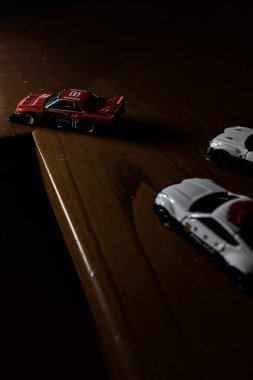 Cenova, İtalya - 20th NOVEMBER 2025 - Nissan Skyline Turbo Super Silueti 'nin kırmızı ve siyah yarış kıyafetleri içindeki Takara Tomi kopyaları Nissan Skyline GT-R R34 ve Japon polis üniformalarındaki Nissan Fairlady 350Z al