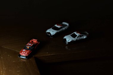 Cenova, İtalya - 20th NOVEMBER 2025 - Nissan Skyline Turbo Super Silueti 'nin kırmızı ve siyah yarış kıyafetleri içindeki Takara Tomi kopyaları Nissan Skyline GT-R R34 ve Japon polis üniformalarındaki Nissan Fairlady 350Z al