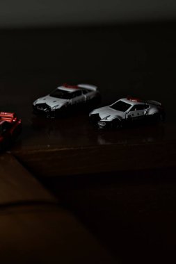 Cenova, İtalya - 20th NOVEMBER 2025 - Nissan Skyline Turbo Super Silueti 'nin kırmızı ve siyah yarış kıyafetleri içindeki Takara Tomi kopyaları Nissan Skyline GT-R R34 ve Japon polis üniformalarındaki Nissan Fairlady 350Z al