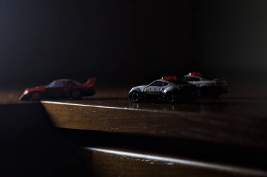 Cenova, İtalya - 20th NOVEMBER 2025 - Nissan Skyline Turbo Super Silueti 'nin kırmızı ve siyah yarış kıyafetleri içindeki Takara Tomi kopyaları Nissan Skyline GT-R R34 ve Japon polis üniformalarındaki Nissan Fairlady 350Z al