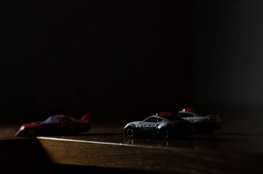 Cenova, İtalya - 20th NOVEMBER 2025 - Nissan Skyline Turbo Super Silueti 'nin kırmızı ve siyah yarış kıyafetleri içindeki Takara Tomi kopyaları Nissan Skyline GT-R R34 ve Japon polis üniformalarındaki Nissan Fairlady 350Z al