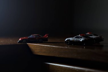 Cenova, İtalya - 20th NOVEMBER 2025 - Nissan Skyline Turbo Super Silueti 'nin kırmızı ve siyah yarış kıyafetleri içindeki Takara Tomi kopyaları Nissan Skyline GT-R R34 ve Japon polis üniformalarındaki Nissan Fairlady 350Z al