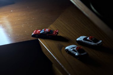 Cenova, İtalya - 20th NOVEMBER 2025 - Nissan Skyline Turbo Super Silueti 'nin kırmızı ve siyah yarış kıyafetleri içindeki Takara Tomi kopyaları Nissan Skyline GT-R R34 ve Japon polis üniformalarındaki Nissan Fairlady 350Z al