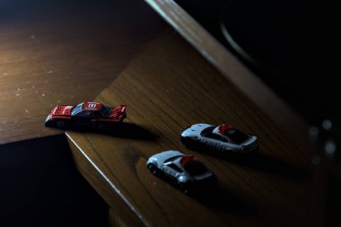 Cenova, İtalya - 20th NOVEMBER 2025 - Nissan Skyline Turbo Super Silueti 'nin kırmızı ve siyah yarış kıyafetleri içindeki Takara Tomi kopyaları Nissan Skyline GT-R R34 ve Japon polis üniformalarındaki Nissan Fairlady 350Z al