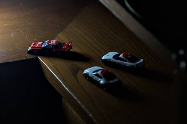 Cenova, İtalya - 20th NOVEMBER 2025 - Nissan Skyline Turbo Super Silueti 'nin kırmızı ve siyah yarış kıyafetleri içindeki Takara Tomi kopyaları Nissan Skyline GT-R R34 ve Japon polis üniformalarındaki Nissan Fairlady 350Z al