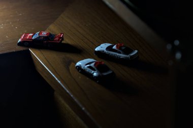 Cenova, İtalya - 20th NOVEMBER 2025 - Nissan Skyline Turbo Super Silueti 'nin kırmızı ve siyah yarış kıyafetleri içindeki Takara Tomi kopyaları Nissan Skyline GT-R R34 ve Japon polis üniformalarındaki Nissan Fairlady 350Z al